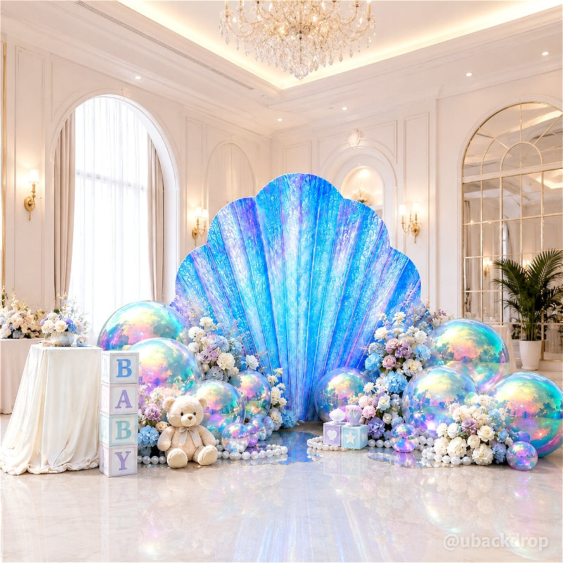 Blue iridescent seashell backdrop stand with balloons and baby blocks