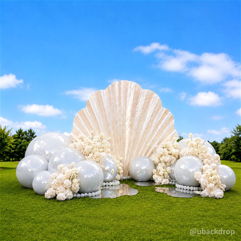 Giant seashell backdrop stand with pearls on a grassy lawn
