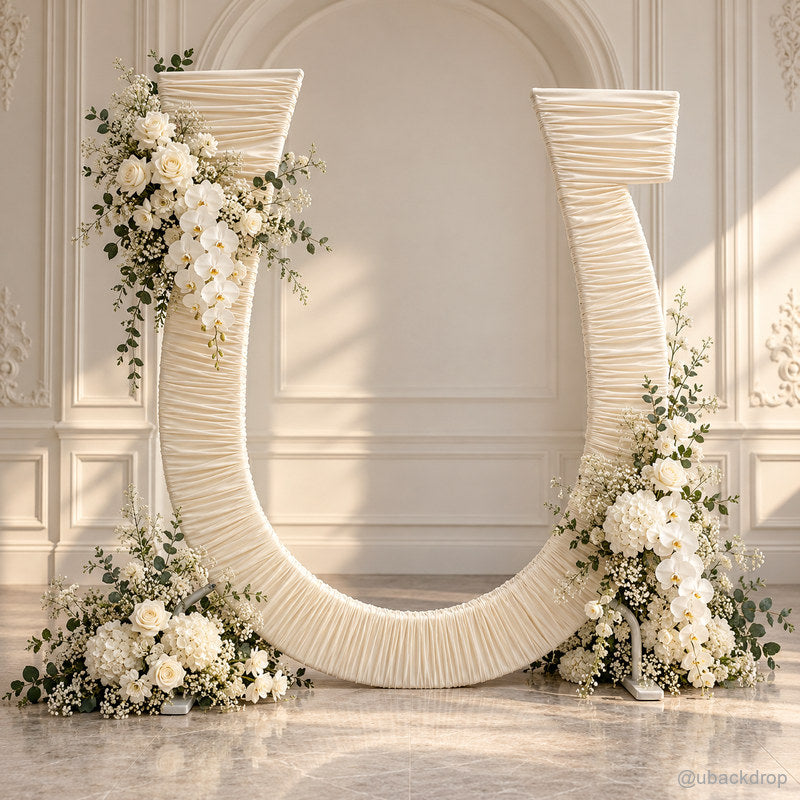 Ivory ruched u shaped wedding arch with white flowers and greenery