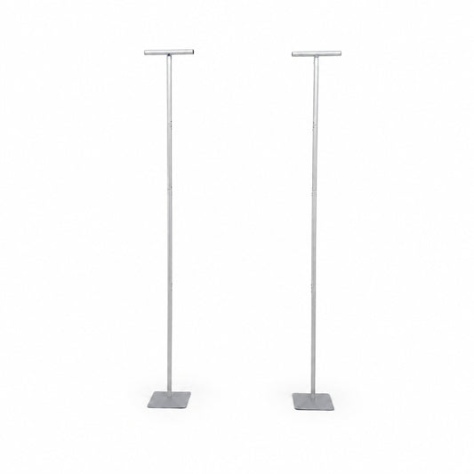 Two silver telescopic metal stands with square bases on white